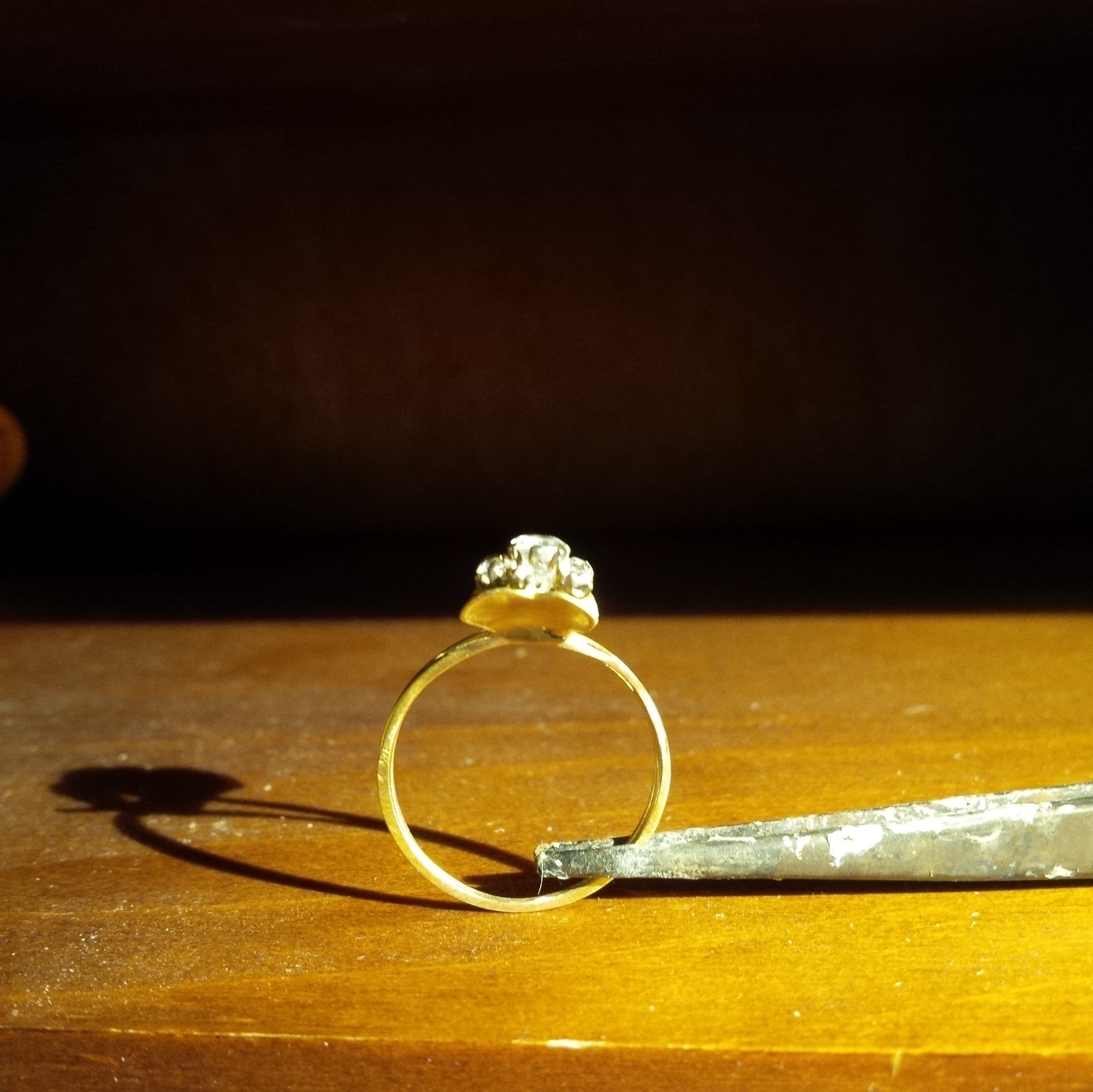 Cliquer pour remplacer cette image Bague en or et diamants posée sur l’établi